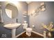 Stylish powder room with elegant fixtures, mirror, and contemporary decor with neutral wall paint at 9949 Stable Stone Ter, Fishers, IN 46040