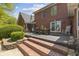 Brick patio featuring an outdoor kitchen, dining area, and lush landscaping, ideal for entertaining at 10220 N Serenity Ln, Mooresville, IN 46158