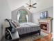 A serene bedroom with a fireplace, vaulted ceilings, and a large arched window offering ample natural light at 10220 N Serenity Ln, Mooresville, IN 46158