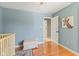 Cozy Bedroom featuring hardwood floors, blue walls, a white crib, and a window view at 10220 N Serenity Ln, Mooresville, IN 46158