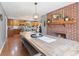 Open dining room featuring a rustic table, brick fireplace, and views into the kitchen at 10220 N Serenity Ln, Mooresville, IN 46158