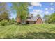 Two-story brick home with a large front yard and mature shade trees creating an inviting view at 10220 N Serenity Ln, Mooresville, IN 46158