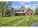 Expansive brick home with a large front lawn and manicured landscaping, inviting curb appeal at 10220 N Serenity Ln, Mooresville, IN 46158