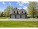 Three-car garage with brick exterior and second-story windows provides ample space and curb appeal at 10220 N Serenity Ln, Mooresville, IN 46158
