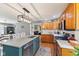 Charming kitchen with wood cabinets, granite countertops, a kitchen island with stainless steel appliances, and hardwood floors at 10220 N Serenity Ln, Mooresville, IN 46158