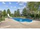 Sparkling in-ground pool with slide feature, surrounded by well-maintained landscaping and mature trees at 10220 N Serenity Ln, Mooresville, IN 46158