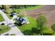 Aerial view of a quaint green home with charming porch, detached garage, and bridge access to neighborhood and farmland at 10776 S 250 W, Flat Rock, IN 47234