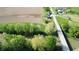Aerial view of home with lush green yard, driveway, landscaping, detached garage, large lot, bridge, and trees at 10776 S 250 W, Flat Rock, IN 47234