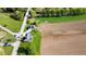 Aerial view of a quaint green home with charming porch, detached garage, and bridge access to neighborhood and farmland at 10776 S 250 W, Flat Rock, IN 47234