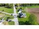 Aerial view of a quaint green home with charming porch, detached garage, and bridge access to neighborhood and farmland at 10776 S 250 W, Flat Rock, IN 47234
