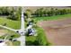 Aerial view of a quaint green home with charming porch, detached garage and bridge access to neighborhood and farmland at 10776 S 250 W, Flat Rock, IN 47234