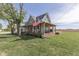 Inviting two-story farmhouse with wraparound porch, rocking chairs, and American flag, set on a large lot at 10776 S 250 W, Flat Rock, IN 47234