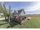 Beautiful two-story farmhouse featuring a wraparound porch with rocking chairs and a spacious green yard at 10776 S 250 W, Flat Rock, IN 47234