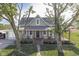 Attractive two-story farmhouse featuring a covered porch with rocking chairs and an attached garage at 10776 S 250 W, Flat Rock, IN 47234