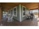 Inviting front porch with rustic wood floors, rocking chairs, and view to an adjacent field at 10776 S 250 W, Flat Rock, IN 47234