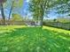 Expansive backyard featuring a lush lawn, privacy fence, mature trees, and a storage shed, perfect for outdoor activities at 1234 Yellowstone Way, Franklin, IN 46131
