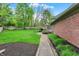 Well-maintained backyard with brick paver pathway, manicured landscaping and large lawn at 13494 Dallas Ln, Carmel, IN 46033