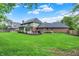 Expansive green lawn complemented by mature trees, patio and home with a sunroom at 13494 Dallas Ln, Carmel, IN 46033