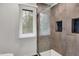 Bathroom with glass door shower, small window, and tiled walls at 13494 Dallas Ln, Carmel, IN 46033