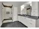 Bathroom featuring a double vanity, walk-in shower with a glass door and dark tile accents at 13494 Dallas Ln, Carmel, IN 46033