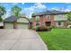 Traditional brick home with a three-car garage, manicured lawn, and mature landscaping at 13494 Dallas Ln, Carmel, IN 46033