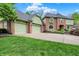 Inviting brick home with an attached three-car garage, green lawn, and trimmed shrubs at 13494 Dallas Ln, Carmel, IN 46033