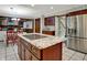 Kitchen island featuring granite countertops, wood cabinets, and stainless steel appliances, plus access to the dining area at 13494 Dallas Ln, Carmel, IN 46033