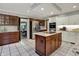 Open kitchen with stainless steel appliances, granite countertops, kitchen island, and white and wood cabinets at 13494 Dallas Ln, Carmel, IN 46033