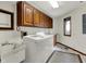 Bright laundry room equipped with washer, dryer, sink, cabinets, and tiled floor at 13494 Dallas Ln, Carmel, IN 46033