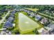 Aerial view features a serene pond surrounded by luxurious homes, some featuring private pools, in a beautiful neighborhood at 13934 Salsbury Creek Dr, Carmel, IN 46032