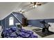 Multi-purpose room in attic with blue accent wall, sloped ceilings, and natural light at 13934 Salsbury Creek Dr, Carmel, IN 46032