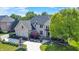 Elegant brick home boasts a manicured lawn, beautiful landscaping, and a circular driveway for a grand entrance at 13934 Salsbury Creek Dr, Carmel, IN 46032