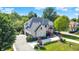 Aerial view of a stunning brick home with a three car garage, lush greenery, and a circular driveway at 13934 Salsbury Creek Dr, Carmel, IN 46032