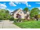 Beautiful two-story brick home with a well-manicured lawn, lush landscaping, and a long driveway at 13934 Salsbury Creek Dr, Carmel, IN 46032