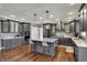 Spacious kitchen boasts a large island, gray cabinetry, stainless steel appliances, and hardwood flooring at 13934 Salsbury Creek Dr, Carmel, IN 46032