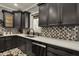 Close up of modern kitchen with grey cabinets, white countertops, and decorative backsplash at 13934 Salsbury Creek Dr, Carmel, IN 46032
