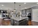 Open-concept view of kitchen and dining area with dark hardwood floors and grey cabinets at 13934 Salsbury Creek Dr, Carmel, IN 46032