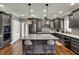 Modern kitchen with grey cabinets, stainless steel appliances, and a large center island with seating at 13934 Salsbury Creek Dr, Carmel, IN 46032