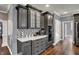 Modern kitchen with grey cabinets, built-in stainless steel oven, and decorative backsplash at 13934 Salsbury Creek Dr, Carmel, IN 46032