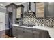 Close up of modern kitchen with grey cabinets, stainless steel refrigerator and gas cooktop at 13934 Salsbury Creek Dr, Carmel, IN 46032