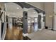 Open-concept living room with dark hardwood floors, grey accents and a kitchen in the background at 13934 Salsbury Creek Dr, Carmel, IN 46032