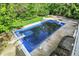 Backyard pool with diving board, surrounded by a concrete deck and lush greenery at 13934 Salsbury Creek Dr, Carmel, IN 46032