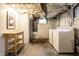 Unfinished basement includes a modern washer and dryer, and a wooden storage cart at 1451 N Grant Ave, Indianapolis, IN 46201