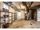 View of the unfinished basement featuring exposed ducts, brick column, and storage shelving at 1451 N Grant Ave, Indianapolis, IN 46201