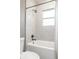 This bathroom features a bathtub and shower, clean white tile, and updated fixtures at 1451 N Grant Ave, Indianapolis, IN 46201