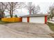 View of the two-car detached garage, paved driveway, and wooden fence at 1451 N Grant Ave, Indianapolis, IN 46201