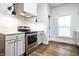 Kitchen with stainless steel appliances, range hood and decorative lighting at 1451 N Grant Ave, Indianapolis, IN 46201