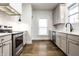 Kitchen with grey cabinets, stainless appliances, and light tile backsplash at 1451 N Grant Ave, Indianapolis, IN 46201