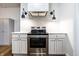Kitchen with grey cabinets, stainless steel appliances, modern range hood and lighting at 1451 N Grant Ave, Indianapolis, IN 46201