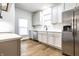 Kitchen with grey cabinetry, subway tile backsplash, stainless steel appliances, and hardwood floors at 1451 N Grant Ave, Indianapolis, IN 46201
